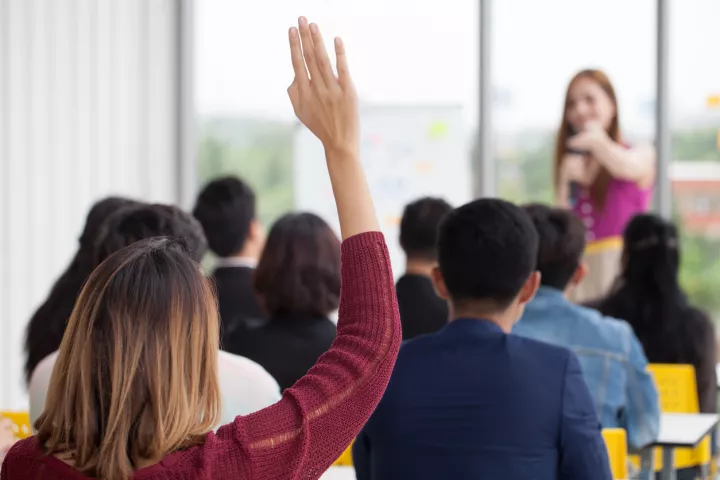 Woman raising hand in classroom