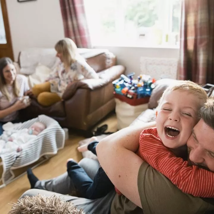 man hugging young boy in home . happy scene