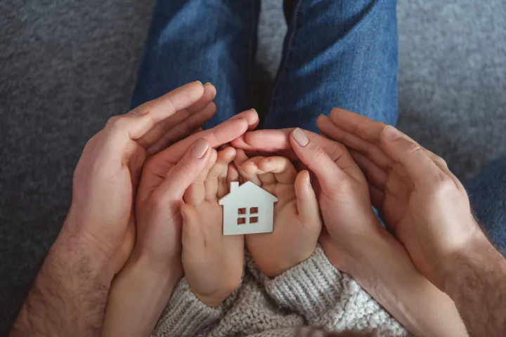 Hands holding a house