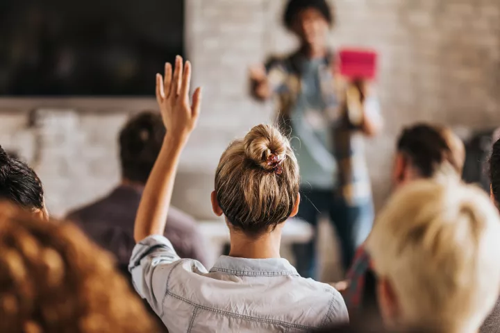 Woman raising hand in training scene