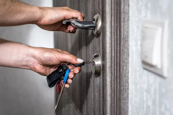 person opening a door with a key