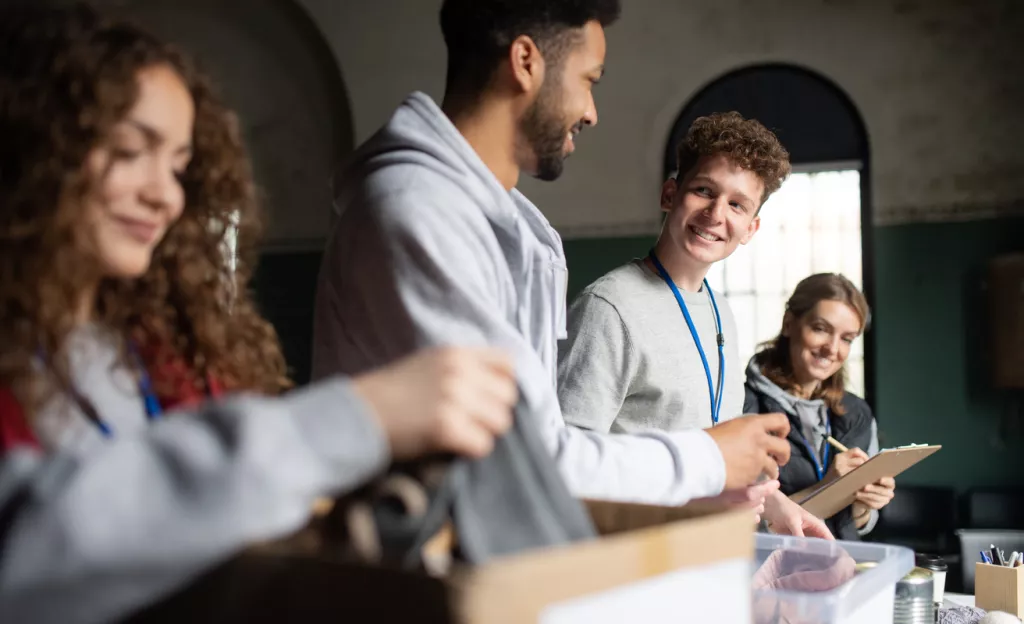 4 young adults packing boxes