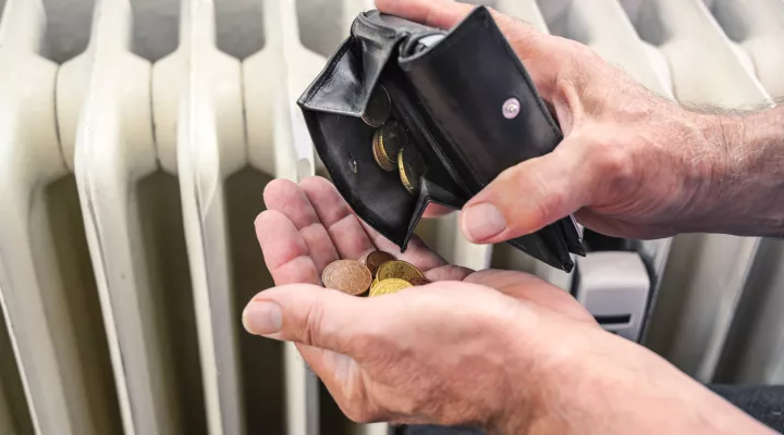 hands of person beside radiator checking how much money is in purse